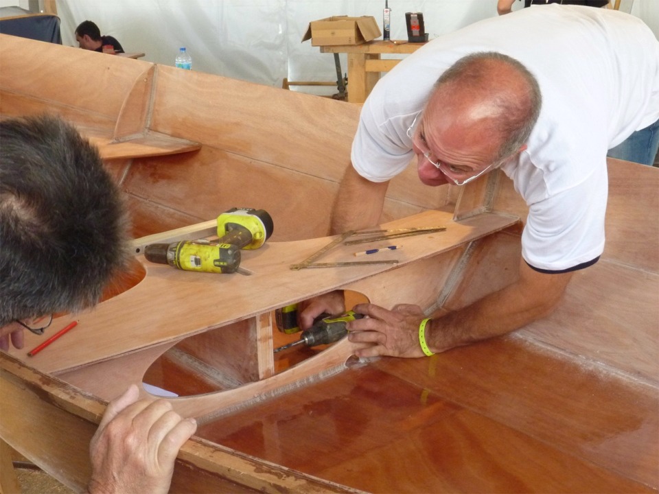 Gérard perce à travers la jambe arrière du puits de dérive l'ancrage de la patte d'oie d'écoute de grand-voile qui passe ensuite à travers le banc central. 