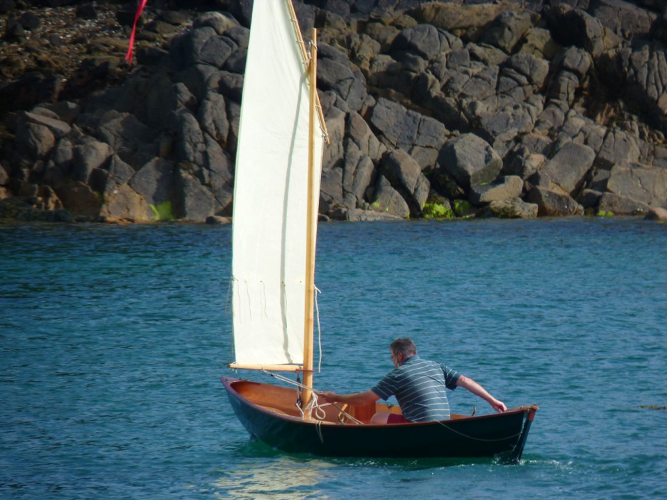 J'ai attrapé l'écoute à pleine main car je suis en train d'empanner : je pousse la barre de la main droite, tandis que je tire la voile de la gauche afin d'accompagner son passage d'un bord sur l'autre. 