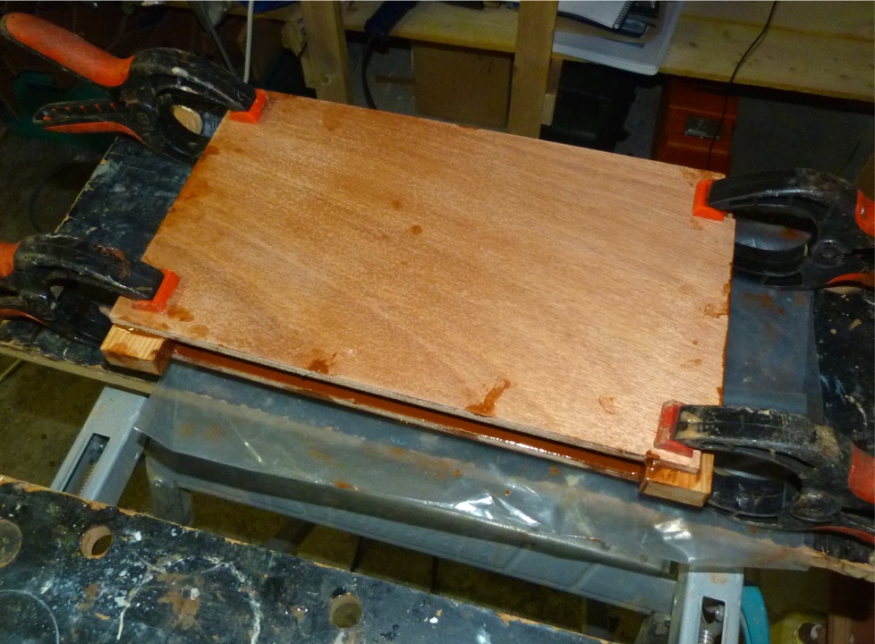 Et voila. J'avais commenc&eacute; par passer une couche d'impr&eacute;gnation &agrave; l'&eacute;poxy "claire" sur la face ext&eacute;rieure des joues, ce qui fait que mon m&eacute;lange d'&eacute;poxy charg&eacute;e ne tachera pas le contreplaqu&eacute; : un petit pon&ccedil;age effacera toutes ces traces. Si je n'avais pas pr&eacute;-impr&eacute;gn&eacute;, la r&eacute;sine charg&eacute;e serait rentr&eacute;e dans la surface du bois et il aurait &eacute;t&eacute; beaucoup plus difficile d'effacer les traces (seule solution : retirer l'&eacute;paisseur de bois tach&eacute; en pon&ccedil;ant). 