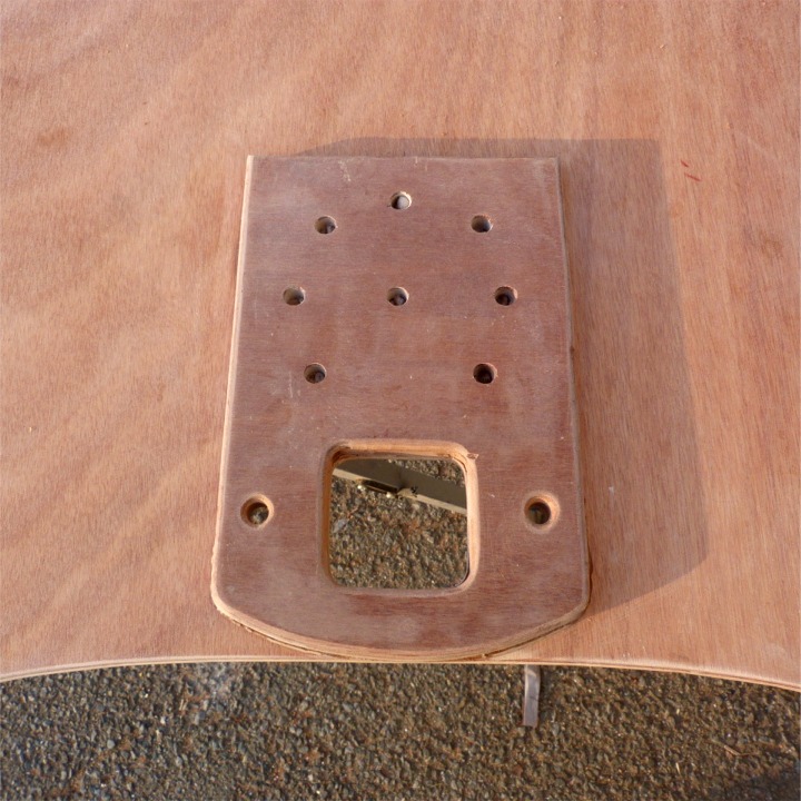 Voici le renfort d'étambrai collé sous le dessus du caisson étanche avant. Les trous de part et d'autre de l'étambrai serviront à saisir le hale-bas de guidant, par exemple, les autres, disposés en rond, servent (dans mon esprit au moins) à favoriser la diffusion de l'époxy chargée de ce collage sur l'ensemble de la surface de contact. 