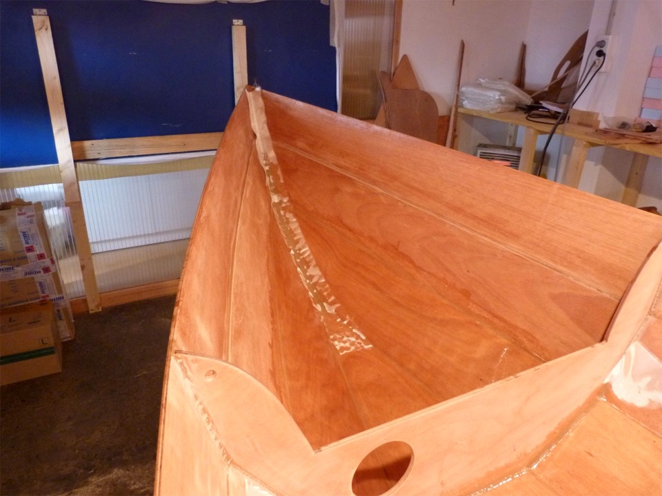 Nous ajoutons une bande de renfort dans l'&eacute;trave et dans l'&eacute;tambot. Les deux paires de bord&eacute;s du haut ne sont pas stratifi&eacute;es afin de limiter le poids de la coque. En effet, la stratification sur une face ajoute environ 350 g par m2, soit 2.5 kg environ pour les deux faces. Ce poids serait multipli&eacute; par 2 ou 3 si l'on stratifiait toute la surface des deux cot&eacute;s, sans apporter d'avantage significatif. 