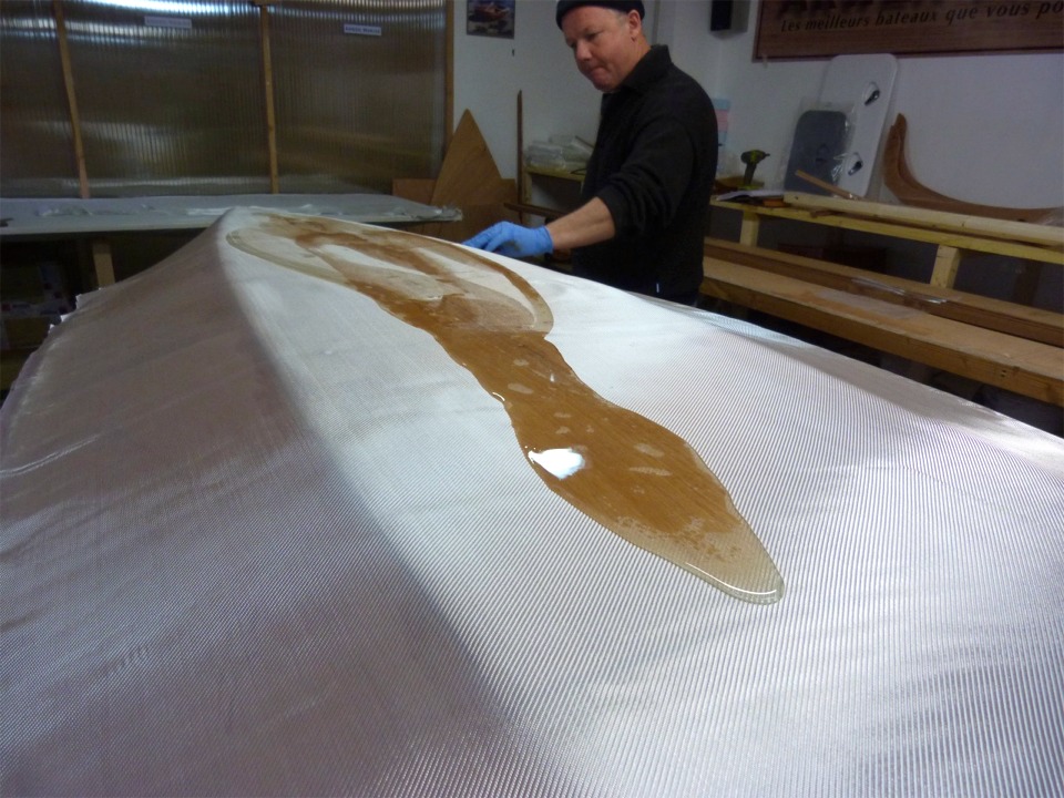 Nous venons de verser 240 ml de r&eacute;sine &eacute;poxy sur le tissu de verre couvrant l'ext&eacute;rieur de la coque, et Herv&eacute; l'&eacute;tale &agrave; la squeegee. 