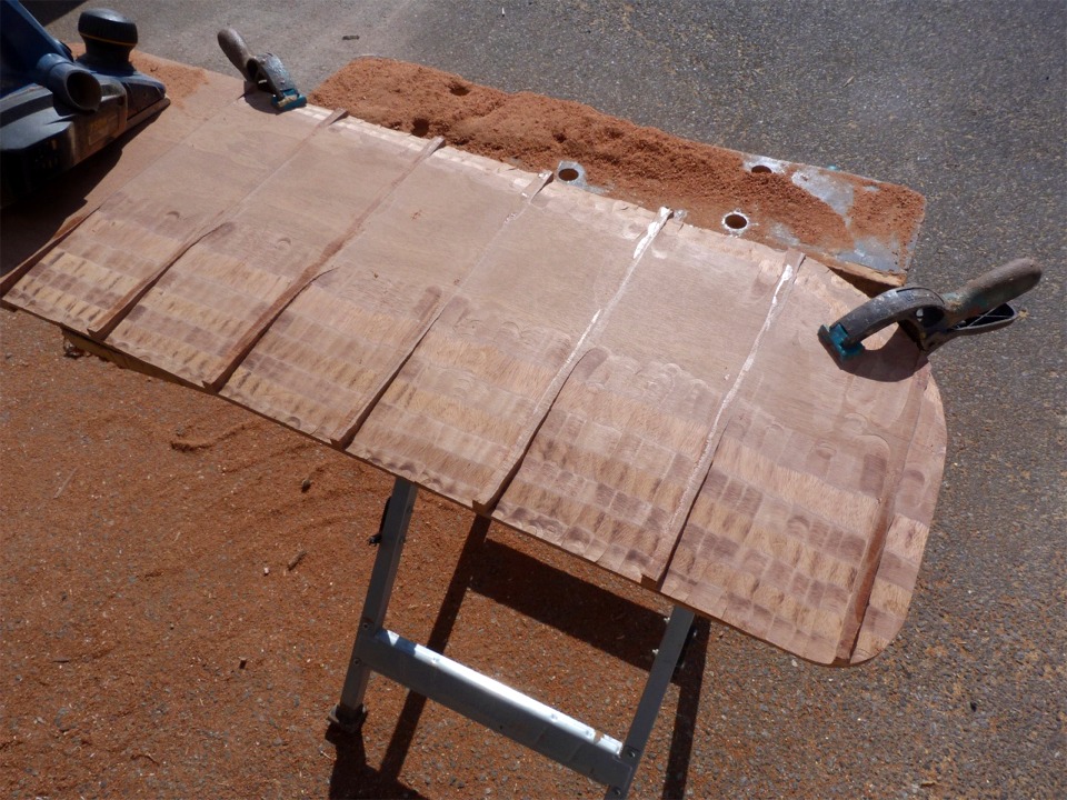 J'utilise le décapeur thermique pour ramollir la colle et décoller délicatement mes guides, que je vais réutiliser sur l'autre face de la dérive, ce qui est une façon de m'assurer de sa symétrie (sans compter l'économie de moyens). Il ne reste plus qu'à "gommer" les saillies sous les empreintes des guides, ce que je vais faire au rabot électrique, puis à passer un léger coup de rabot pour égaliser partout, et je finirai à la ponceuse à bande. 