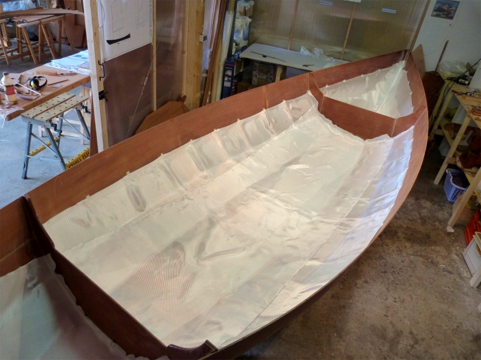 Jamais deux sans trois : j'ajoute une dernière pièce centrale qui couvre la sole et l'essentiel des bordés 1. On aura donc jusqu'à 486 g/m2 de tissu de verre (3 couches de 162 g/m2) au fond de la coque, ce qui lui assurera une rigidité maximum, tout en plaçant l'essentiel du poids de la fibre et de la résine le plus bas possible. Au total, il y a là 13 m2 de tissu, soit 2.1 kg pour la fibre "sèche". 