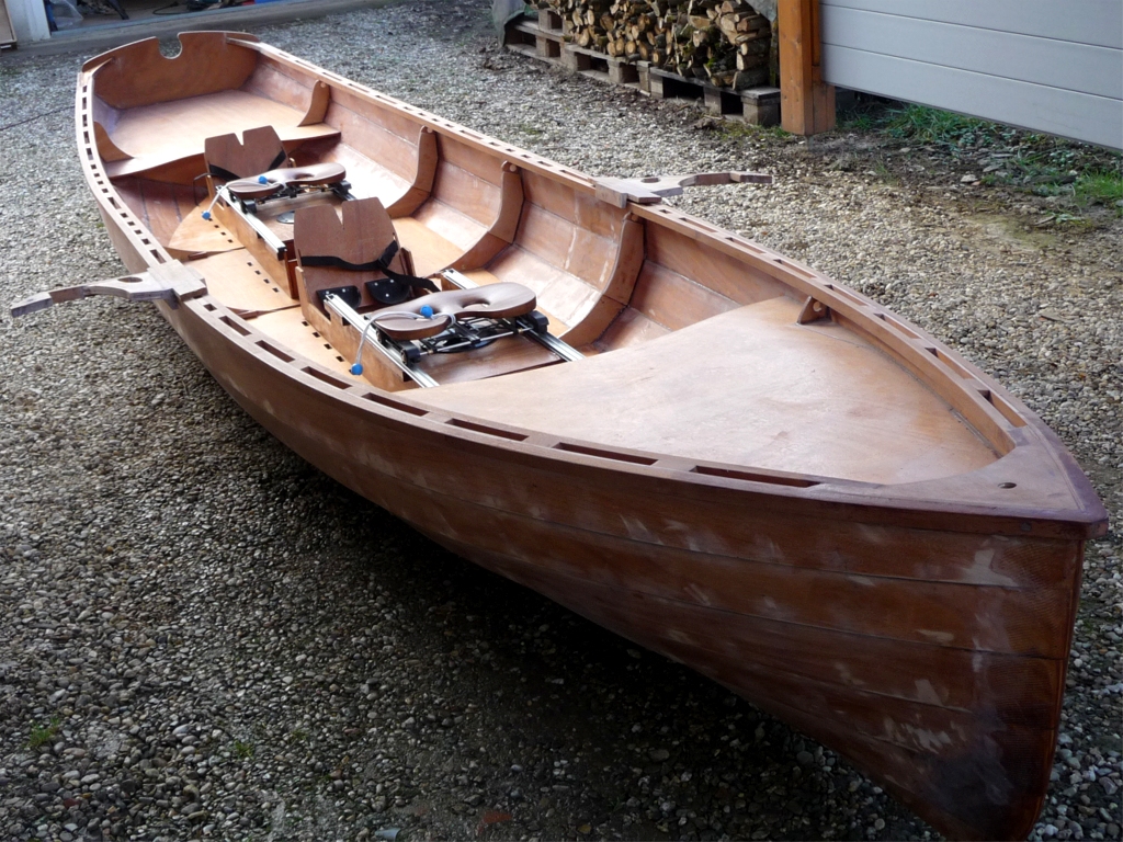 Jean-Claude recherchait un bateau d'aviron élégant à construire et il est tombé sous le charme de la Yole de Chester. Mais la yole est trop courte car Jean-Claude souhaite installer à son bord deux coulisses d'aviron de son crû, et il n'a donc pas hésité à intercaler un tronçon de 49 centimètres entre les deux moitiés des virures du kit. Jean-Claude a aussi ajouté une troisième membrure (il a d'ailleurs doublé toutes leurs allonges), ainsi qu'une serre ajourée pour rigidifier le haut du bordé afin de fixer ses portants. Et ce n'est pas fini : Jean-Claude souhaite ensuite doter sa yole d'un gréement et de dérives latérales à la hollandaise... 