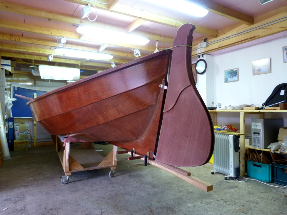 Montage des ferrures de gouvernail : j'ai accroché un tasseau au skeg grâce à deux serre-joints afin de poser le gouvernail dans son prolongement, et j'ai ajouté une cale de 12 mm pour me donner un peu de marge en cas de talonnage. De plus, le profil du bas du gouvernail est incurvé vers le haut afin de limiter le risque qu'il touche lors d'une mise à l'eau, par exemple. Le gouvernail est posé sur la cale et tenu en haut par un bout de fil électrique en attendant que je positionne et fixe aiguillots et fémelots. 