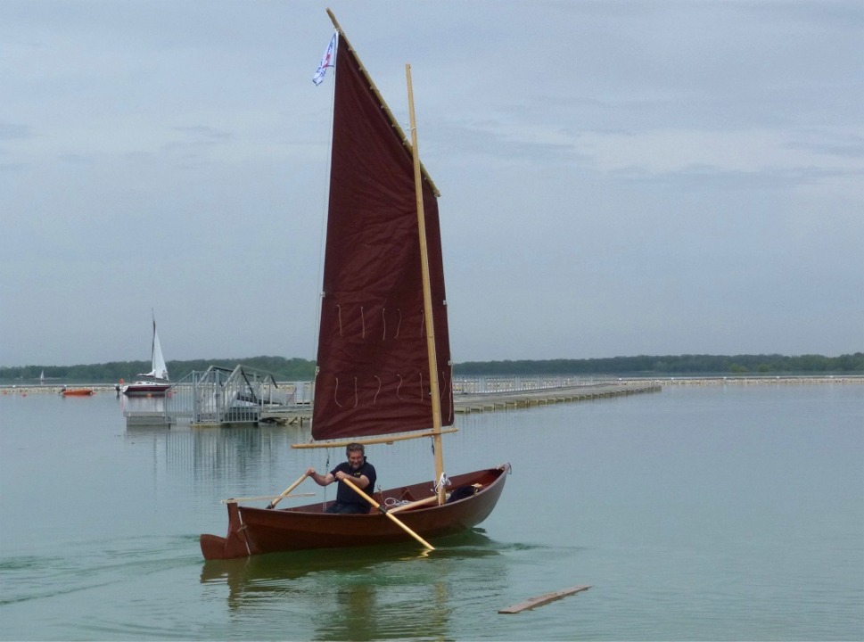 Et c'est parti, j'ai sorti les avirons pour m'écarter du rivage afin de mettre la dérive, baisser le safran et remplir les deux réservoirs de ballast, pour l'instant fermés. Je précise que la planche qui flotte à coté de Gandalf n'appartient à aucun bateau Arwen Marine présent sur le plan d'eau. Gandalf flotte visiblement bien au-dessus de sa flottaison théorique en charge. Ces essais montreront que le ballast doit en effet être rempli lorsque l'on navigue seul à bord ou en équipage léger, mais il doit être vidé quand on est nombreux et musclés, afin de récupérer de la hauteur de franc-bord. 