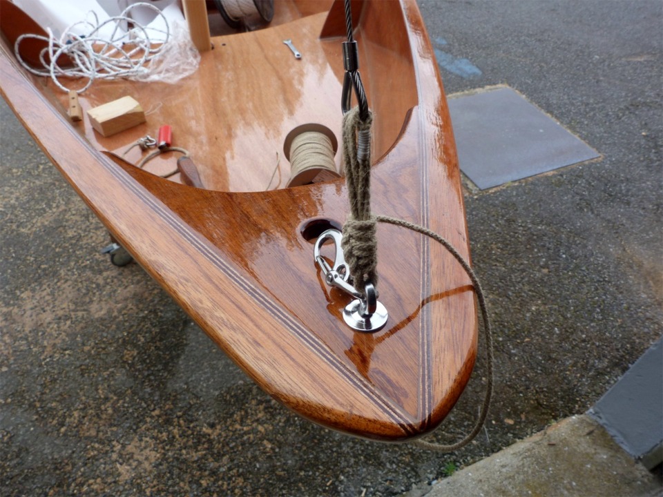 Cette vue de la proue de "Gustave" montre le piton inox fix&eacute; &agrave; travers la guirlande sur lequel sont frapp&eacute;s l'&eacute;tai et l'amure du foc. L'&eacute;tai est fix&eacute; par une ligature car c'est la "variable d'ajustement" du gr&eacute;ement dormant : les deux haubans sont connect&eacute;s par des mousquetons sur leur cad&egrave;ne (pour la simplicit&eacute; de fixation), et le gr&eacute;ement est donc raidi par l'avant. 