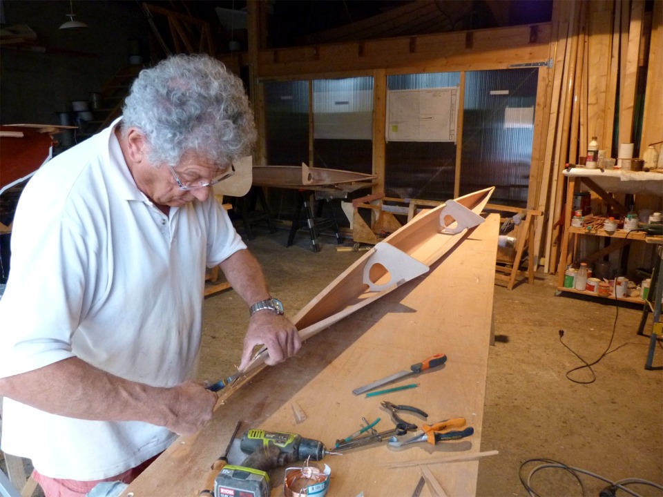 C'est presque fini pour la couture des flotteurs : Pierre resserre les sutures du flotteur tribord, et on aper&ccedil;oit le b&acirc;bord sur la table au fond. 
