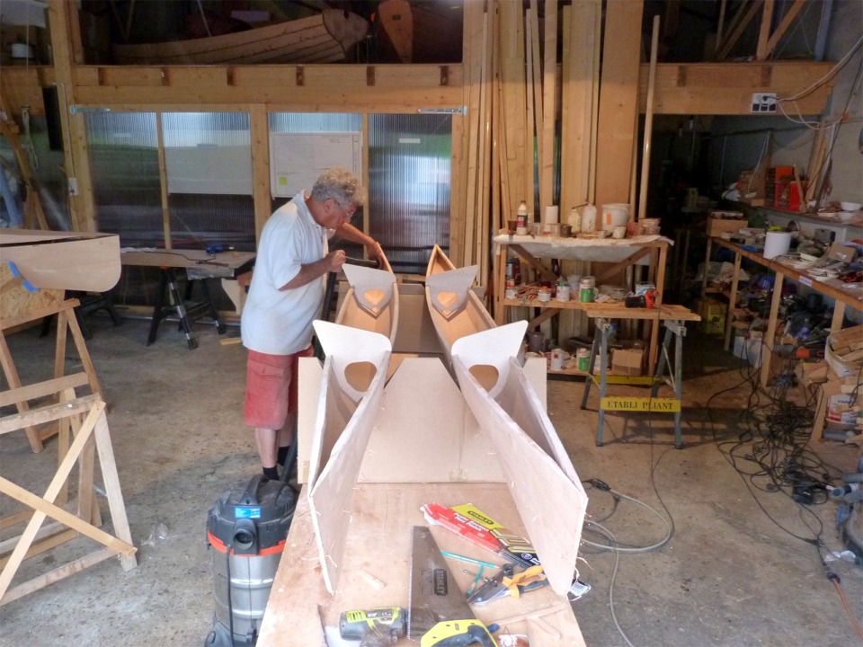 Pierre passe un coup d'aspirateur avant que nous commencions &agrave; coller les flotteurs. Nous les avons cal&eacute;s sur la table de travail gr&acirc;ce &agrave; des berceaux jumeaux en carton : il faut savoir improviser... Notez que nous avons oppos&eacute; les flotteurs : celui de b&acirc;bord est &agrave; droite et celui de tribord est &agrave; gauche (car c'est &agrave; la mode actuellement). 