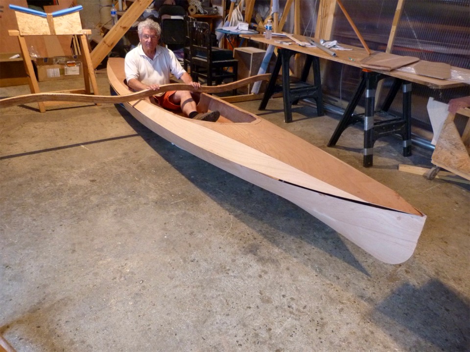 Retour au 4 juin : Pierre fait un essayage du si&egrave;ge arri&egrave;re du Wood Duck Double. C'est le bras arri&egrave;re qui traverse le cockpit du Wood Duck Double devant lui, le bras avant traversera sur le pont devant le cockpit. Nous avons pos&eacute; le kayak sur des coussins afin d'&eacute;viter d'ab&icirc;mer le fond du bateau, car l'ext&eacute;rieur de la coque n'est pas encore stratifi&eacute;. On voit que le pont n'est que pos&eacute; sur la coque, pas encore coll&eacute;. 