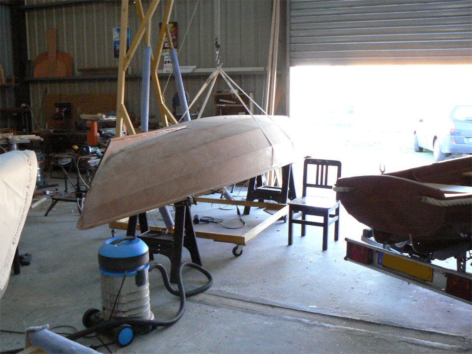 La coque est pos&eacute;e sue les tr&eacute;teaux et soutenue par ma grue (rappelez-vous : ceinture et bretelles !) car je travaille en dessous : je repasse de l'&eacute;poxy sur les joints entre les bancs/pontages et les cloisons. 