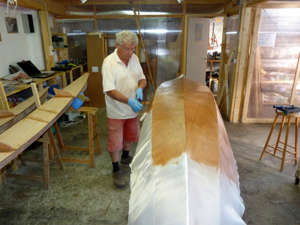 Pierre fait la stratification de l'ext&eacute;rieur de la coque du Wood Duck Double au rouleau : cette technique est plus facile que la raclette sur les parois quasi-verticales des panneaux lat&eacute;raux, on prend nettement moins de r&eacute;sine dans les chaussures... 