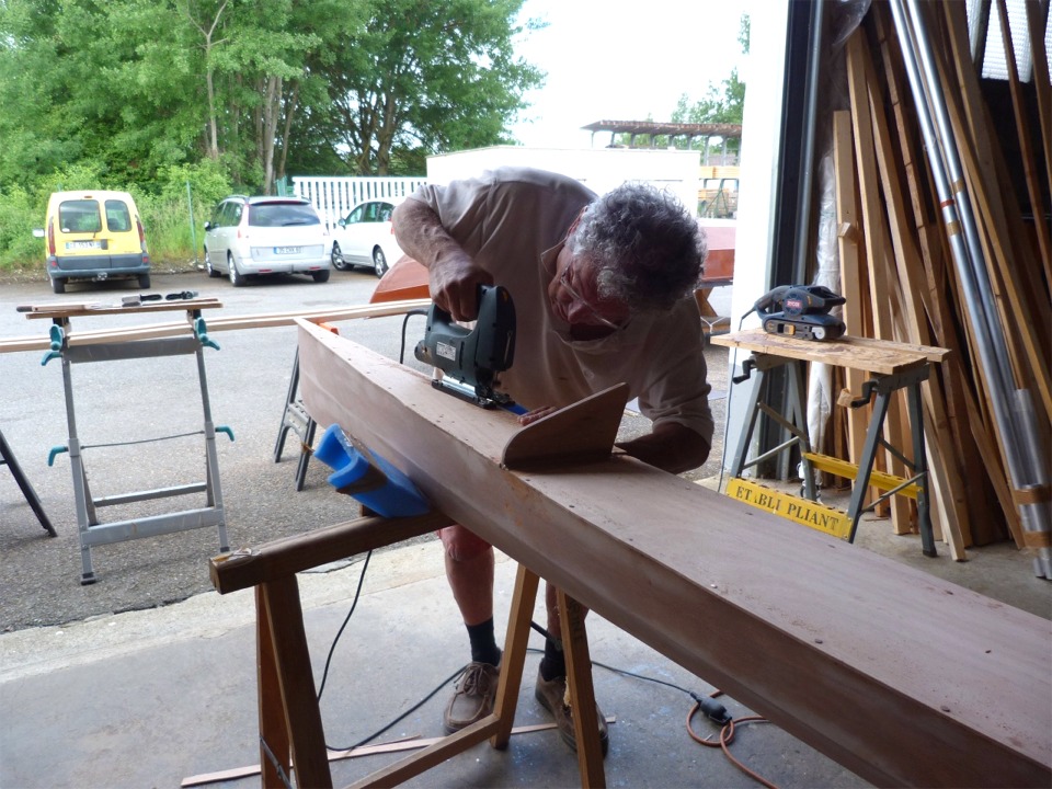Pierre coupe l'exc&eacute;dent de contreplaqu&eacute; sur les cot&eacute;s. La coupe est d&eacute;grossie &agrave; la scie sauteuse et finie &agrave; la ponceuse. 