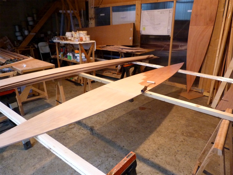 Je passe la couche d'impr&eacute;gnation sur l'une des deux soles, on aper&ccedil;oit l'autre verticale &agrave; l'arri&egrave;re-plan. Je traiterai ensuite tous les bord&eacute;s qui sont empil&eacute;s sur la gauche. On voit que j'ai d&eacute;ja coll&eacute; les scarfs de toutes ces pi&egrave;ces. 