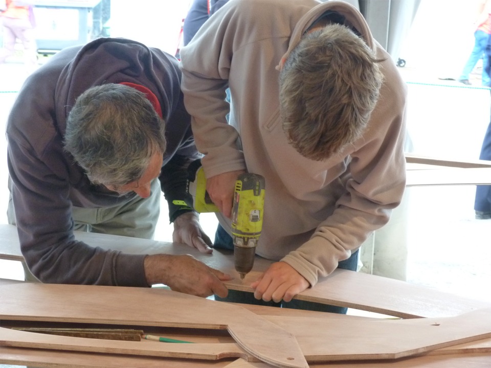 François et Michel ont commencé à percer les trous des sutures. On voit qu'ils percent à travers les deux bordés numéro 1 posés l'un sur l'autre en miroir. 
