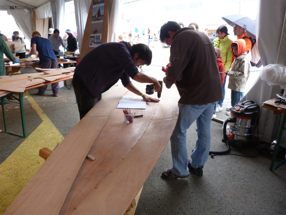 On aperçoit derrière Yann, sur la gauche, l'équipe du chantier Icaraï qui construit le Gazic 12. Notez comment les spectateurs sont habillés... 