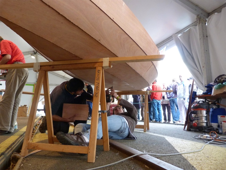 Nous avions tracé l'emplacement du puits de dérive sur la sole avant de "coudre" ensemble les panneaux et nous avons percé par l'intérieur les trous des deux vis qui tiendront le puits sur la sole en plus du collage et des joints-congés. Erwan est en train de les fraiser par en-dessous.