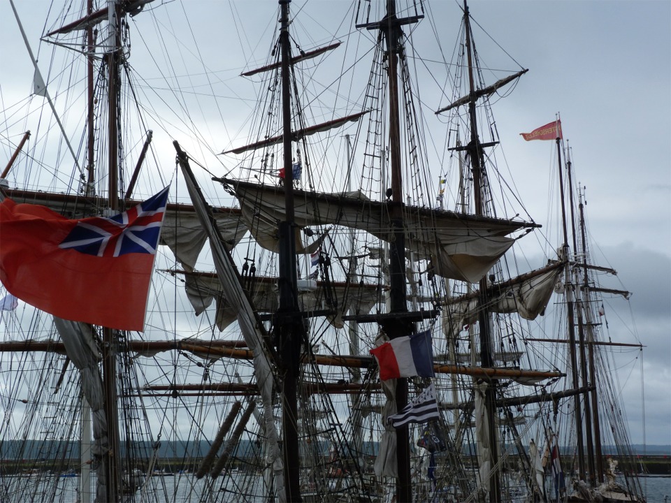 J'ai pris cette photo sur mon chemin du matin vers notre chapiteau de l'espace "Construire un bateau" : un bateau anglais portant un pavillon de courtoisie breton sous le français. L'étiquette navale proscrit l'envoi de deux pavillons sur une même drisse comme insultant pour le pavillon du bas, résultat sans doute inverse à l'intention... 