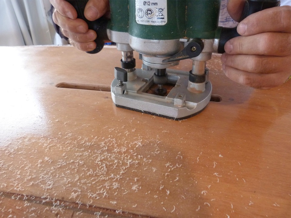 Gérard utilise une seconde défonceuse équipée d'une fraise en quart de rond pour arrondir l'arête sur tout le pourtour de l'ouverture. 