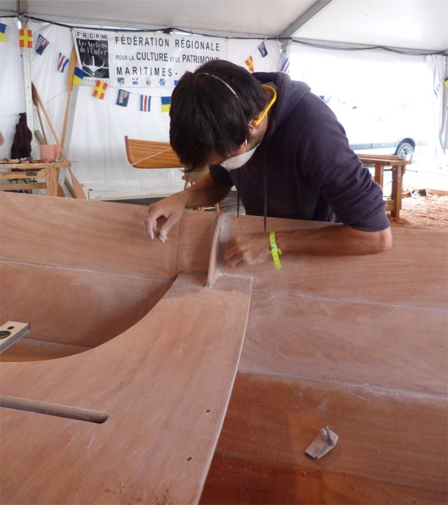 Toute la surface intérieure est poncée afin d'obtenir une surface "propre". Ici, Yann ponce les joints-congés de la membrure centrale. 