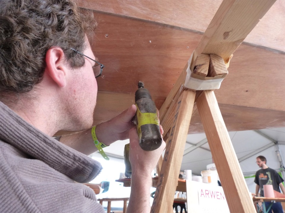 Erwan fraise les trous de fixation des cale-pieds à travers les bordés 1. 
