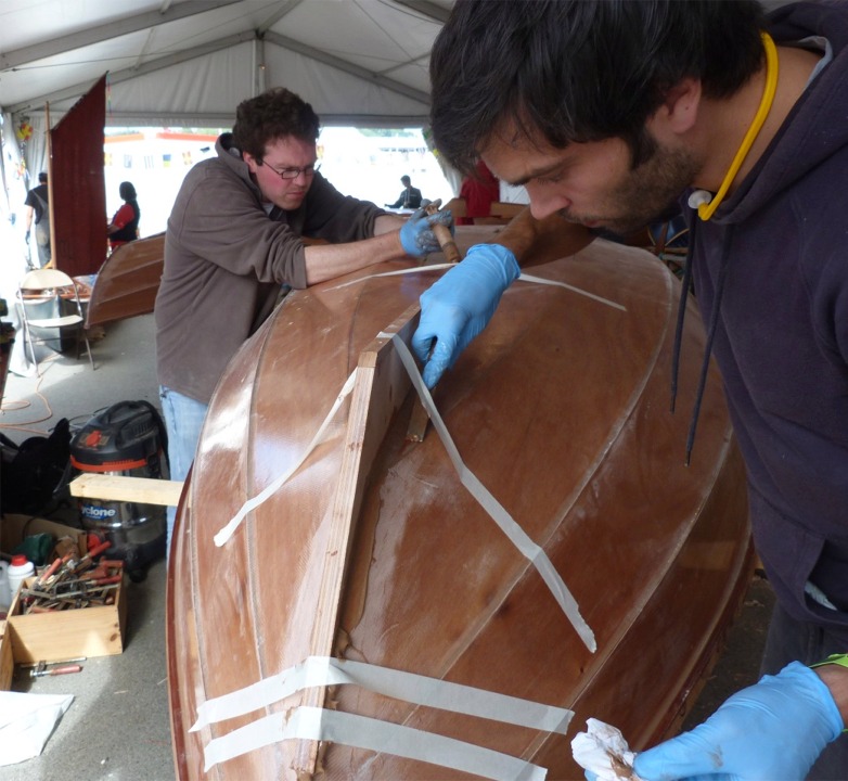 Le cordon d'époxy est lissé à la cuiller, qui lui donne une section concave en arc de cercle, puis Yann râcle l'excédent d'époxy chassée sur les bords du joint. 