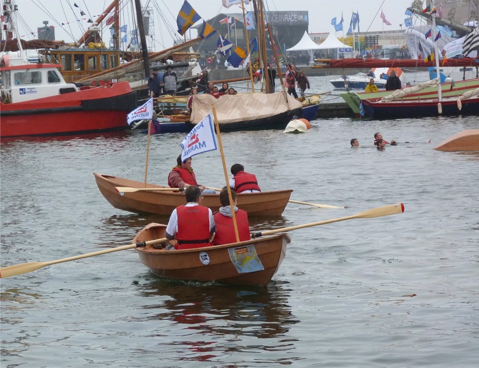 A l'arrière-plan à droite, l'équipage de la pirogue a chaviré celle-ci afin de tester la procédure de redressement : on monte sur le flotteur pour enfoncer celui-ci afin de lui faire faire le trajet retour en élevant au maximum la coque centrale hors de l'eau afin de la vider pendant le redressement. 
