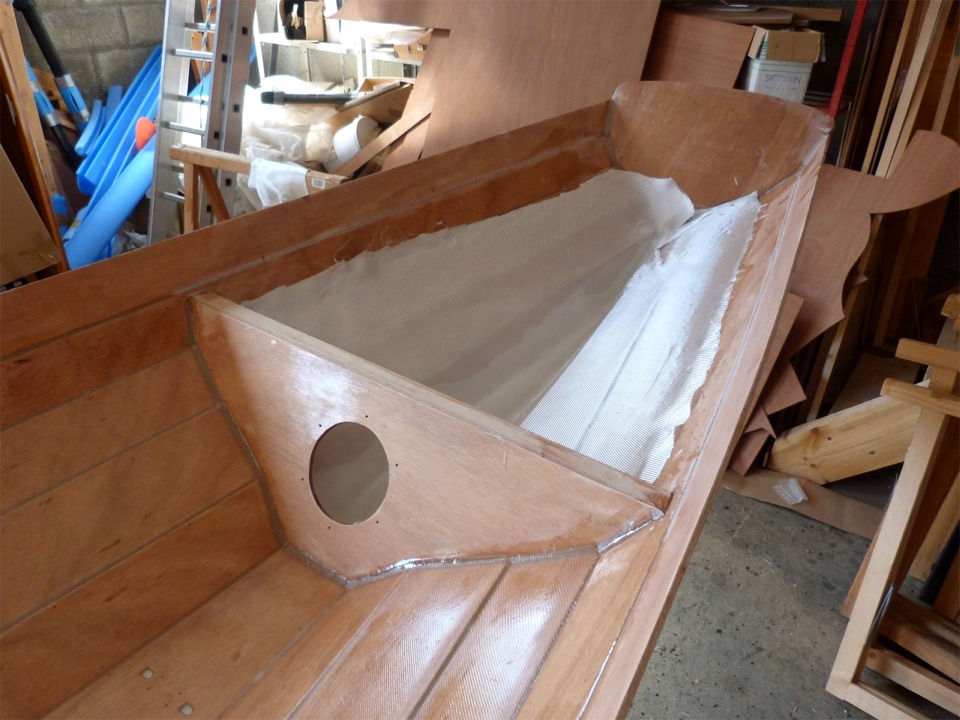 Le mercredi matin, nous avons ponc&eacute; tous ces nouveaux joints et encha&icirc;nons en d&eacute;nut d'apr&egrave;s-midi avec la stratification du compartiment central (on voit la diff&eacute;rence de texture entre les bord&eacute;s 4 et 5, non stratifi&eacute;s, et la partie basse de la coque). Le tissu de verre est pr&ecirc;t &agrave; &ecirc;tre satur&eacute; d'&eacute;poxy dans le compartiment arri&egrave;re. Le d&eacute;montage temporaire des membrures noua a permis de stratifier toute la longueur du compartiment central du Wherry Tandem d'un seul tenant, alors qu'il aurait fallu couper, au moins partiellement, la pi&egrave;ce de tissu si nous les avions laiss&eacute;es en place. Ces coupes auraient affaibli le stratifi&eacute; et auraient caus&eacute; des irr&eacute;gularit&eacute;s de surface difficles &agrave; rectifier. 