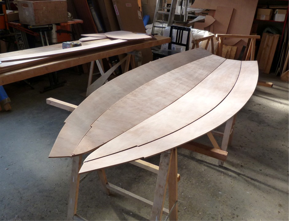 L'int&eacute;r&ecirc;t de cette impr&eacute;gnation est de prot&eacute;ger les pi&egrave;ces de rayures ou autres dommages qui seraient caus&eacute;s au cours des manipulations de construction. Cette premi&egrave;re couche &eacute;vite ensuite de tacher le contreplaqu&eacute; avec l'&eacute;poxy charg&eacute;e des joints, et la coque pourra donc &ecirc;tre vernie sur l'int&eacute;rieur. Cette premi&egrave;re couche d'&eacute;poxy est ensuite ponc&eacute;e pour obtenir une surface lisse qui "accrochera" les collages ou rev&ecirc;tements ult&eacute;rieurs. J'ai commenc&eacute; la couture de la coque : les deux bord&eacute;s 1 sur la ligne de quille, puis j'ai ajout&eacute; les deux bord&eacute;s 2. 