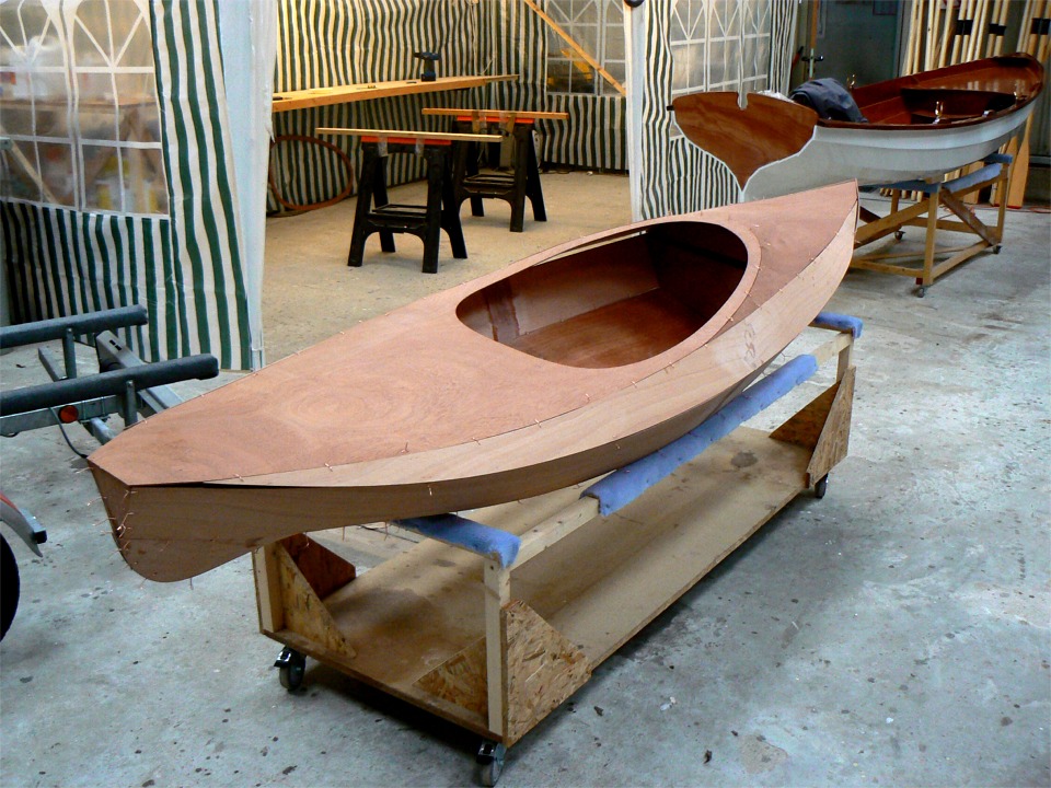 Le pontage est pos&eacute; sur la coque pour voir si tout correspond. A l'arri&egrave;re-plan, on aper&ccedil;oit une Yole de Chester. 