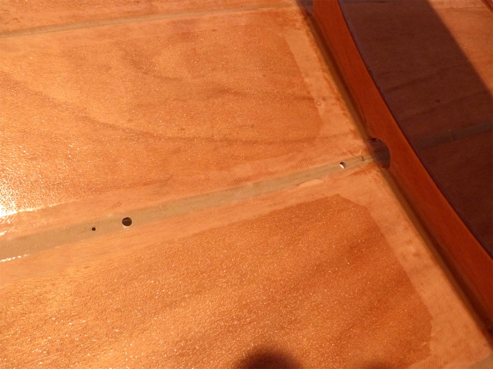 Pendant que le bateau &eacute;tait &agrave; l'envers, j'ai aussi perc&eacute; quatre trous pour le puits de d&eacute;rive : deux petits (4 mm) pour les vis inox qui tiendront les jambes du puits, et deux gros (12 mm) pour rep&eacute;rer l'ouverture basse du puits &agrave; travers la coque. Je r&eacute;aliserai cette ouverture &agrave; la d&eacute;fonceuse, avec une fraise droite &agrave; guide. 