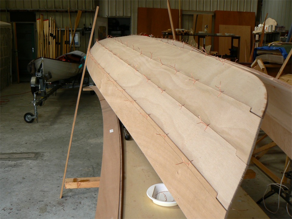 Le bord&eacute; 4 est en place. On voit bien sur cette image les rablures d'&eacute;trave (ou d'&eacute;tambot) qui ne sont pas encore jointives : &agrave; ce stade les sutures ne sont pas tr&egrave;s serr&eacute;es car les bord&eacute;s doivent pouvoir "jouer" pour que la coque prenne sa forme. On aper&ccedil;oit le bord&eacute; 5 pr&ecirc;t au montage, apr&egrave;s un l&eacute;ger pon&ccedil;age sur la feuillure et les bords, bruts de d&eacute;coupe num&eacute;rique. 