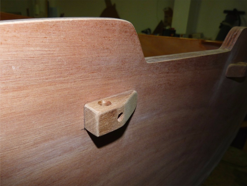 Suite de la construction du Youyou : je viens de monter &agrave; sec (visser sans coller) les filoirs qui serviront &agrave; amarrer les extr&eacute;mit&eacute;s du gros cordage de d&eacute;fense p&eacute;riph&eacute;rique. Le trou vertical recevra le transfilage de fixation du gros cordage et le trou horizontal contient la vis et sera bouch&eacute; par un tapon du m&ecirc;me bois. 