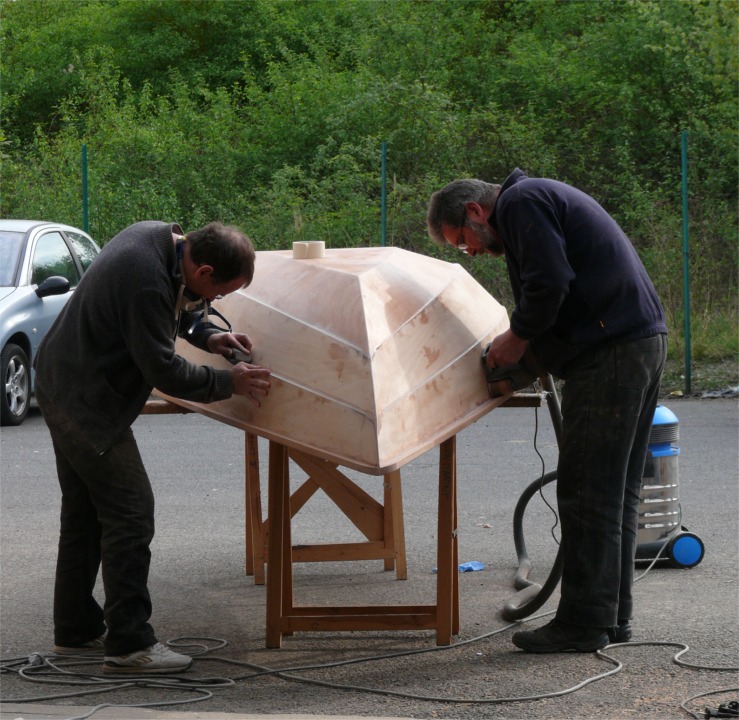 Je passe la ponceuse à bande pendant qu'Olivier finit l'angle d'un clin. 