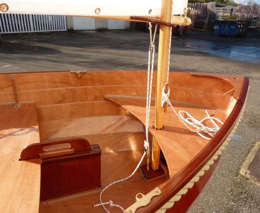 La voile est tenue verticalement par sa drisse (que l'on voit ici au taquet) et par ce palan &agrave; deux brins frapp&eacute; sur la b&ocirc;me juste en arr&egrave;re du point de pivotement sur le m&acirc;t. De ce fait, ce palan a une double fonction : d'abord il exerce une tension sur le guindant, et ensuite il joue &eacute;galement le r&ocirc;le le hale-bas de b&ocirc;me, gr&acirc;ce au court bras de levier entre son capelage et le point d'amure. Il est imp&eacute;ratif que ce palan soit bien &eacute;tarqu&eacute; pour que la voile soit bien &eacute;tablie. Il est toujours navrant de voir des voiles au tiers avec un pli entre le point d'&eacute;coute et le haut du guindant sur l'avant de la vergue &agrave; cause d'une tension insuffisante sur l'amure.