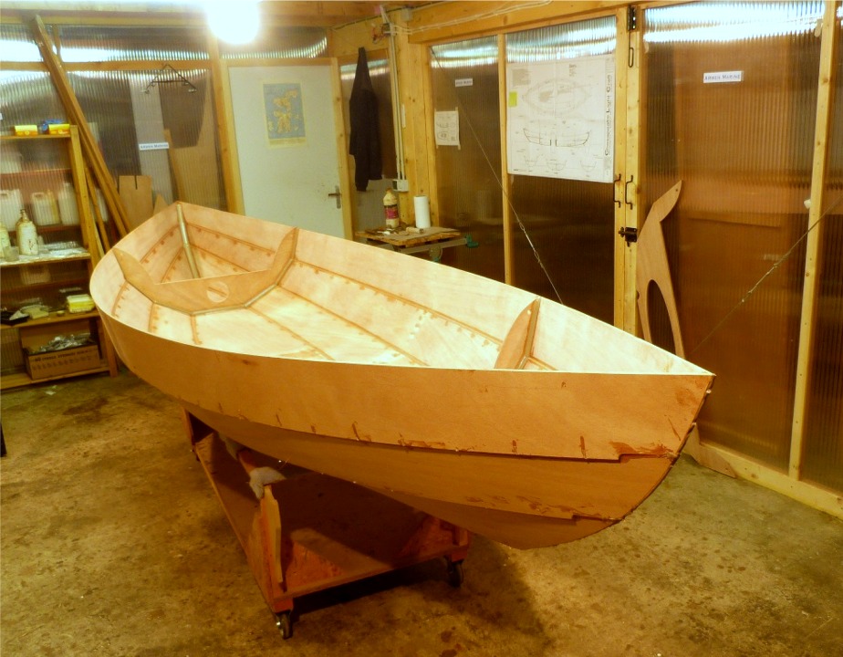 Apr&egrave;s que l'&eacute;poxy de ces premiers collages ait durci, nous avons remis la coque &agrave; l'endroit et j'ai coup&eacute; les sutures de la cloison centrale et l'ai d&eacute;pos&eacute;e. On l'aper&ccedil;oit d'ailleurs appuy&eacute;e contre la porte derri&egrave;re la proue. 