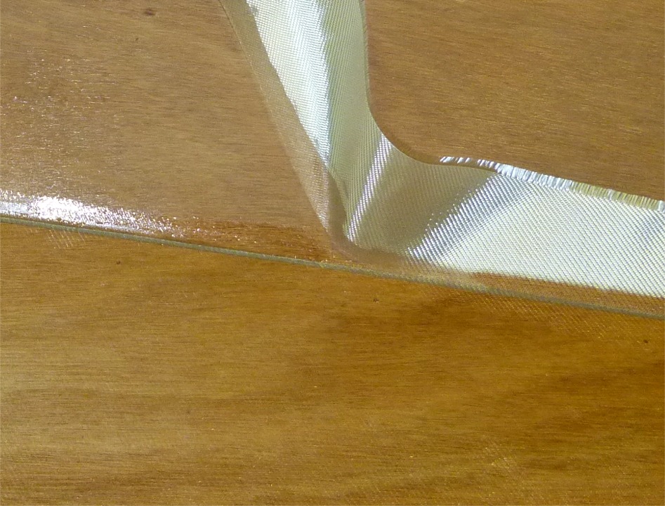 Je coupe le tissu non satur&eacute; &agrave; l'aide de la pointe d'un cutter en m'appuyant sur le bord ext&eacute;rieur des joints ou joints-cong&eacute;s. J'encha&icirc;ne 3 heures plus tard (en fait d&egrave;s que l'&eacute;poxy de stratification ne colle plus au doigt) avec une couche de remplissage de la trame. 