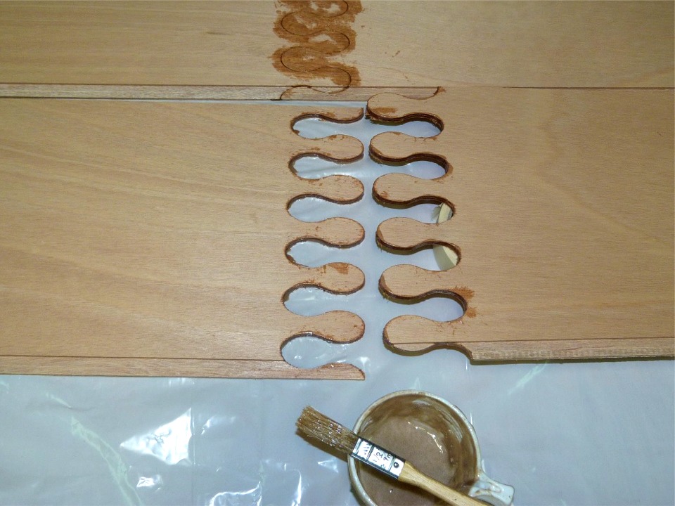 En effet, j'ai été sollicité pour une émission sur la construction à partir de kits, des maisons (en bois), des cuisines, et des bateaux. Je ne participe qu'à ce dernier volet (pour l'instant !) Afin de pouvoir montrer la méthode du "cousu-collé", je commence le collage des joints-puzzle d'un nouveau Skerry, que j'avais prévu de construire au printemps comme bateau de chantier. Sur cette image, je viens d'appliquer au pinceau de l'époxy chargée sur toute la longueur du chant des deux demi-bordés, qui suit les contours de la découpe. 