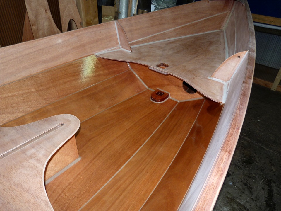 Heureusement, je peux chauffer (mais avec mod&eacute;ration) la partie de l'atelier sous la mezzanine, et je ne suis pas totalement inactif depuis le d&eacute;but de l'hiver. J'ai repass&eacute; une couche d'&eacute;poxy sur la partie basse de l'int&eacute;tieur du Skerry Christophine. Cette image montre bien la diff&eacute;rence entre l'aspect terne et blanch&acirc;tre de l'&eacute;poxy ponc&eacute;e du haut et le brillant de la couche fra&icirc;che. Vue prise vers l'avant, on voit le pied de m&acirc;t et l'&eacute;tambrai. La trappe de visite du caisson avant est excentr&eacute;e pour ne pas &ecirc;tre occult&eacute;e par le m&acirc;t lorsqu'il est en place. 