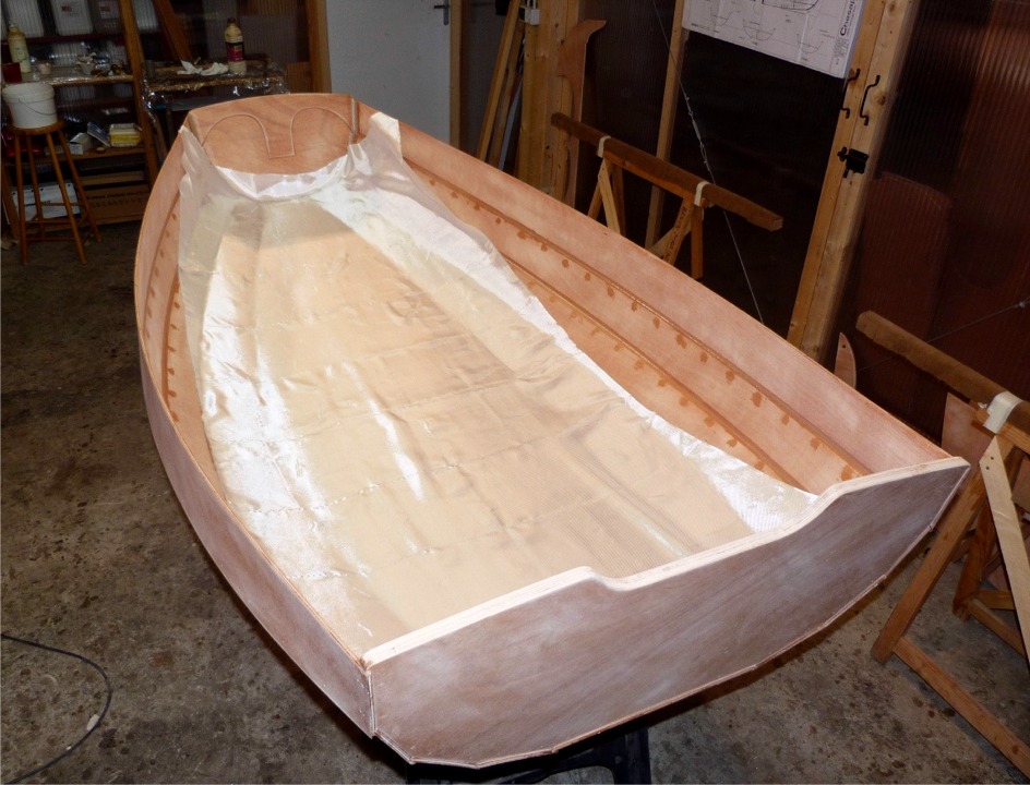 Je drape le tissu de verre sur la surface int&eacute;rieure. Ce tissu d'un m&egrave;tre de large couvrira la sole et les deux bord&eacute;s 1. Un second tissu de verre sera ult&eacute;rieurement stratifi&eacute; sur la m&ecirc;me zone &agrave; l'ext&eacute;rieur de la coque. Les bord&eacute;s 2, 3 et 4 seront seulement couverts de deux couches d'&eacute;poxy qui durciront la surface du bois et la rendront &eacute;tanche. 