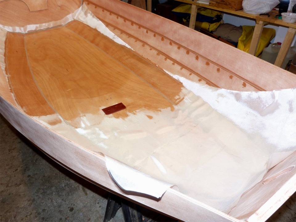 J'&eacute;tale l'&eacute;poxy sur le tissu et la fais p&eacute;n&eacute;trer dans la fibre &agrave; l'aide de la squeegee que l'on aper&ccedil;oit au centre de la sole. J'ai encore pu v&eacute;rifier cette fois-ci qu'il faut compter &agrave; peu pr&egrave;s le m&ecirc;me poids de r&eacute;sine que le poids de fibre de verre : ici j'ai &agrave; peu pr&egrave;s deux m&egrave;tres carr&eacute;s de serg&eacute; de 162 g/m2 (donc 324 g), et j'ai utilis&eacute; 310 g d'&eacute;poxy.