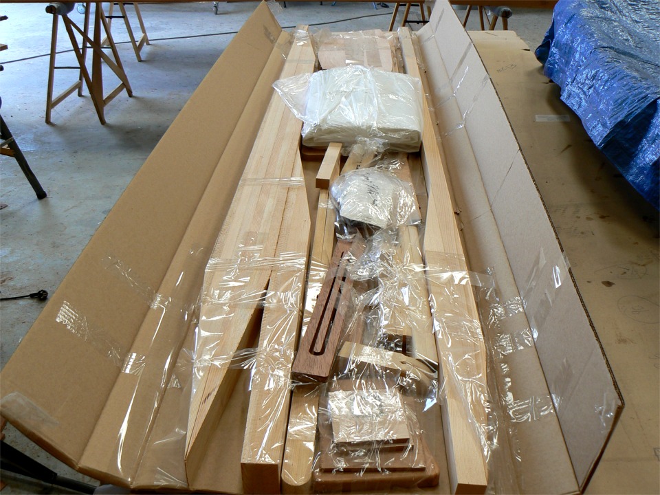 Ouverture du kit "voile" du Jimmy Skiff. A gauche les trois morceaux du m&acirc;t (deux scarfs &agrave; coller), &agrave; droite, la b&ocirc;me avec un seul scarf, et plein de trucs entre les deux, dont la voile. 