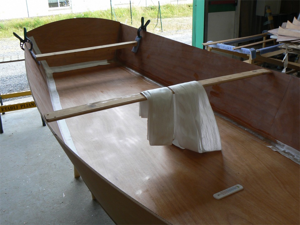 La semaine dernière, j'ai suturé et fait le premier collage de la coque. Maintenant, je passe à la deuxième couche du collage, qui implique des joints-congés partout. Ces joints sont renforcés par deux épaisseurs de bande de tissu de verre stratifiées directement sur les joints.