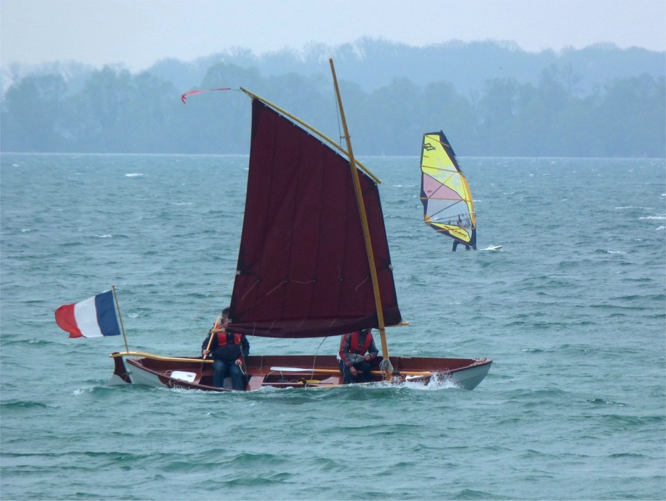 J'ai décidé de garder ma vergue temporaire taillée dans un vieux mât de planche à voile pour remplacer celle en bois que j'avais cassée l'été dernier. Elle est légère et souple, comme on le voit ici. Le transfilage en spirale sur la vergue absorbe une partie de sa flexion, puis lorsque le vent est vraiment fort, la flexion applatit la voile au point de causer le léger pli en diagonale à partir de l'arrière de la seconde bande de ris. 