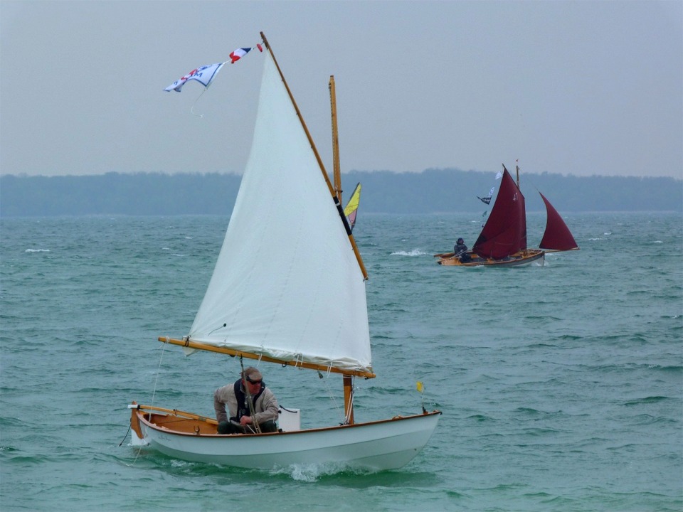 "La Marie Pupuce" rentre au rivage tandis que "Thema" passe à fond à l'arrière-plan. Une planche à voile est dissimulée dans cette image : trouvez-la ! 