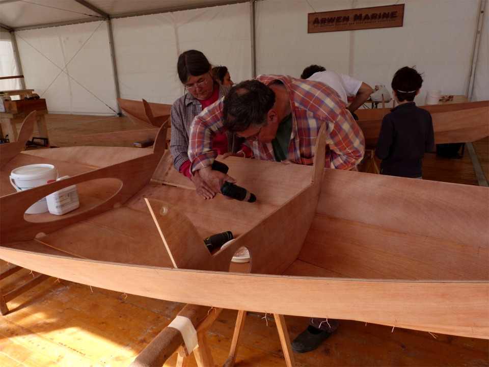 Bernadette immobilise le bordé 2 bâbord tandis que Christian perce un trou de suture.