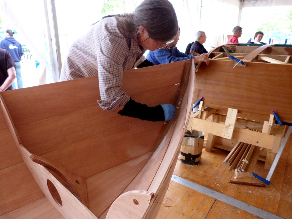 Bernadette racle l'excédent d'époxy chargée repoussé de part et d'autre du joint-congé. 