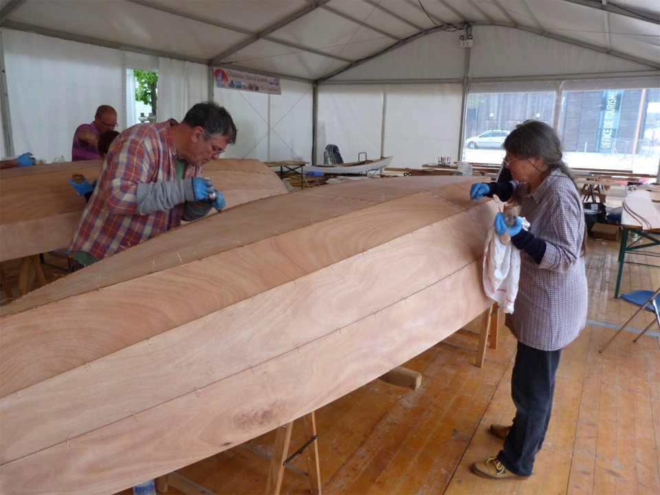 Dernière opération du jour, après le remontage des guirlandes encollées : nous retournons de nouveau les bateaux pour injecter de l'époxy chargée dans tous les joints entre les bordés. Cette époxy est un peu plus liquide (on va dire mayonnaise plutôt que crème de marrons) que celle des joints-congés car elle doit de répandre au maximum dans les joints, sans toutefois couler à travers. 