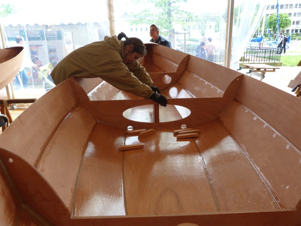 Mes stagiaires avaient commencé sans moi, en remontant la membrure centrale. Nous avons ensuite percé pour les vis du puits de dérive et du pied de mât, et Caroline est ici en train de tenir le puits de dérive tandis que Robert visse par en-dessous. 